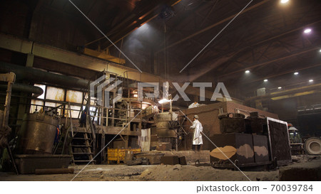 Metal smelting furnace in steel mill. Molten metal pouring, metallurgy, steel casting foundry. Steel manufacturing. Casting shop for gassified models. Metal smelting furnace in steel mill. Molten metal pouring, metallurgy, steel casting foundry. Steel manufacturing. Casting shop for gassified models. 70039784