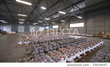 Oil and Gas Wellhead tree equipment production plant. Light turns on in the warehouse. Parts of wellhead fittings and butterfly valves. Equipment for wellhead conncetion of oil and gas wells. Oil and Gas Wellhead tree equipment production plant. Light turns on in the warehouse. Parts of wellhead fittings and butterfly valves. Equipment for wellhead conncetion of oil and gas wells. 70039847