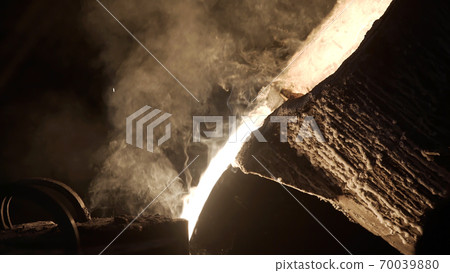 Hard work in a foundry. Metal smelting furnace in steel mill. Molten metal pouring, metallurgy, steel casting foundry. Furnace in which metal is melted. Metallurgical industry Hard work in a foundry. Metal smelting furnace in steel mill. Molten metal pouring, metallurgy, steel casting foundry. Furnace in which metal is melted. Metallurgical industry 70039880