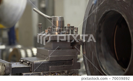Turning lathe in action. Facing operation of metal blank on turning machine with cutting tool. Old turning lathe machine in turning workshop. Operator machining high precision mold part by cnc lathe Turning lathe in action. Facing operation of metal blank on turning machine with cutting tool. Old turning lathe machine in turning workshop. Operator machining high precision mold part by cnc lathe 70039892
