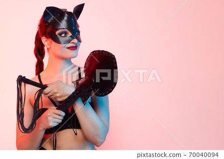 beautiful girl in a cat mask. playfully posing in front of the camera beautiful girl in a cat mask. playfully posing in front of the camera 70040094