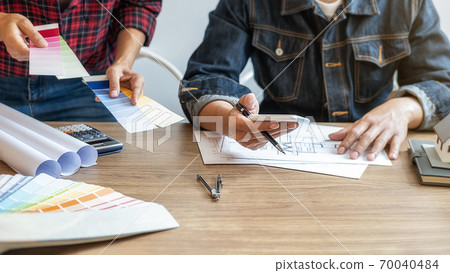 Interior designer and Architect choosing color for house coloring selection in office. Interior designer and Architect choosing color for house coloring selection in office. 70040484