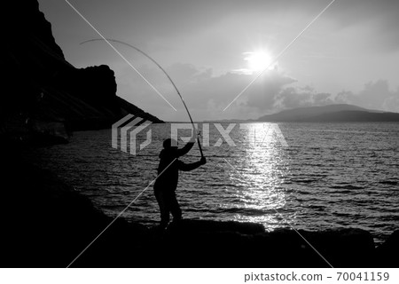 Young man fishing with feathers for mackerel B+W Young man fishing with feathers for mackerel B+W 70041159