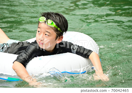 Elementary school boys playing in the river 70042465