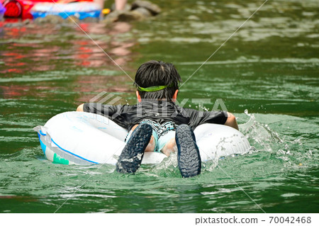 Elementary school boys playing in the river Elementary school boys playing in the river 70042468