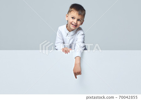 the little boy points to an empty space. thumbs up. white background the little boy points to an empty space. thumbs up. white background 70042855