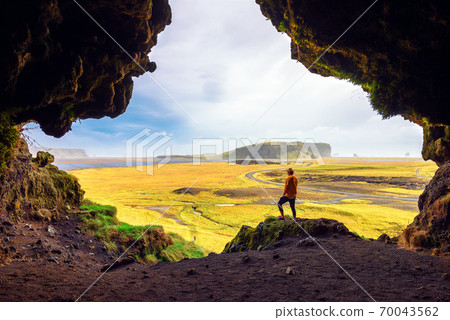 Hiker in the Loftsalahellir Cave near the village of Vik in Iceland Hiker in the Loftsalahellir Cave near the village of Vik in Iceland 70043562