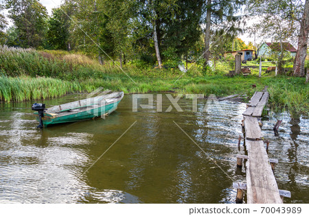 Plastic fishing boat with motor on the bank of the lake in summer day 70043989
