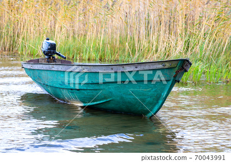 Plastic fishing boat with motor on the lake Plastic fishing boat with motor on the lake 70043991