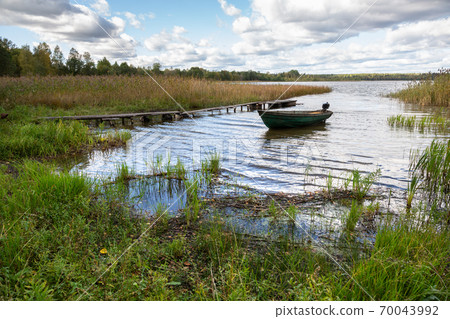 Plastic fishing boat with motor on the lake in summer day Plastic fishing boat with motor on the lake in summer day 70043992