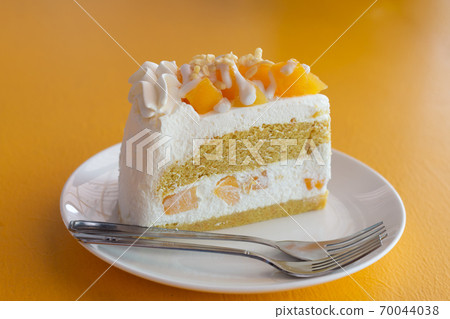 Summer fruit dessert is Mango cheesecake on yellow table background Summer fruit dessert is Mango cheesecake on yellow table background 70044038