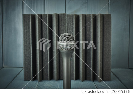 Dynamic microphone for vocals and choirs with acoustic foam in the background and wood in shades of gray and blue 70045336