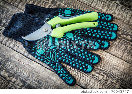 Garden gloves and pruner on wooden boards 70045747