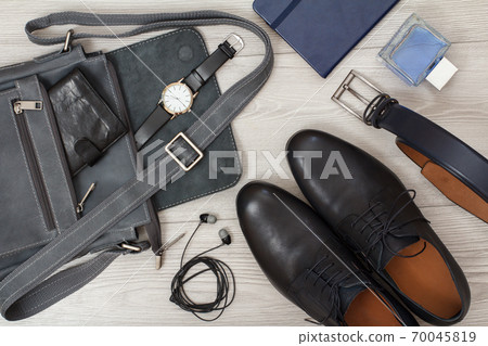 Leather shoulder bag for men with wallet and wristwatch on gray background 70045819