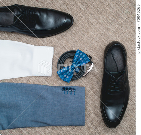 Suit, blue bow tie, leather black shoes and belt. Grooms wedding morning. Close up of modern man accessories 70046269