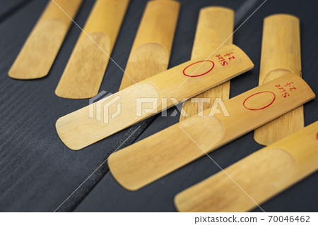 Reeds for a mouthpiece of a wooden instrument on gray wooden background 70046462