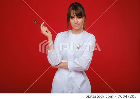 Beautiful girl doctor with a tuning fork stands 70047205