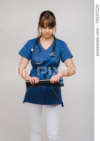 Female Brunette Doctor Looking at Tomography X-ray Film 70047220