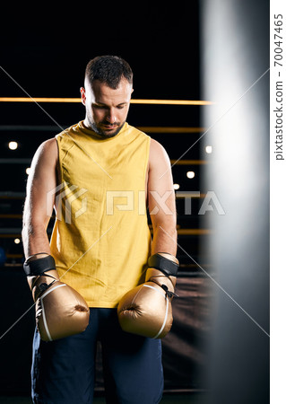 Sad boxing champion standing with his head down Sad boxing champion standing with his head down 70047465
