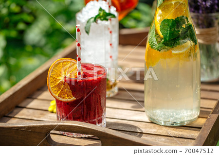 Cold lemonade and cocktails on the wooden tray Cold lemonade and cocktails on the wooden tray 70047512