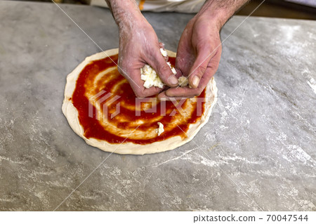 Cooking pizza. Pancake for pizza smeared with ketchup 70047544