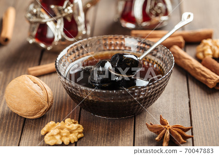 Dark walnut jam on wooden decorated background 70047883