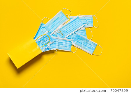 Gift bag with face masks top view on a yellow background. 70047899