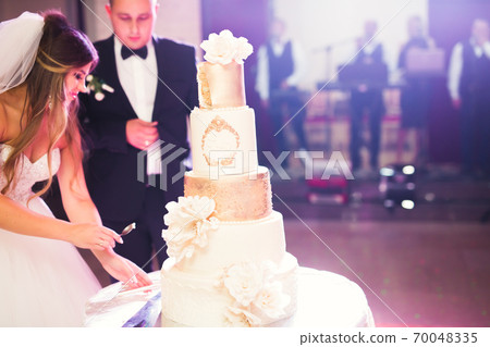 Bride and groom at wedding cutting the wedding cake 70048335