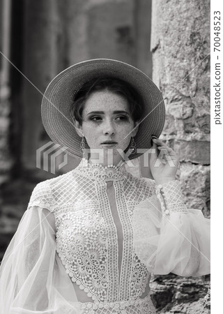 Pretty young caucasian redhead girl in garden and outside with wedding bouquet. 70048523