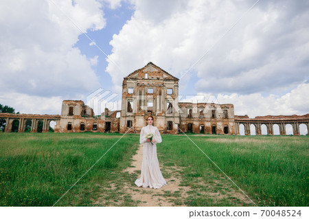Pretty young caucasian redhead girl in garden and outside with wedding bouquet. Pretty young caucasian redhead girl in garden and outside with wedding bouquet. 70048524