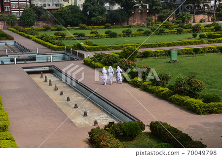 A Muslim schoolgirl walking along the sidewalk of the unfinished castle ruins of Lalbagh Fort Gardens in Dhaka, Bangladesh A Muslim schoolgirl walking along the sidewalk of the unfinished castle ruins of Lalbagh Fort Gardens in Dhaka, Bangladesh 70049798