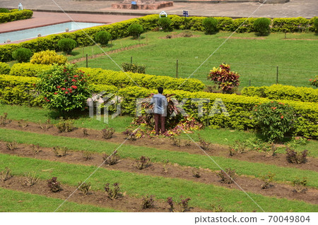 孟加拉國達卡,一名孟加拉國男子正在照料拉伯格堡花園未完成的城堡廢墟 孟加拉國達卡,一名孟加拉國男子正在照料拉伯格堡花園未完成的城堡廢墟 70049804