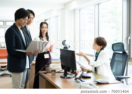 Female boss giving instructions to subordinates in the office 70051404