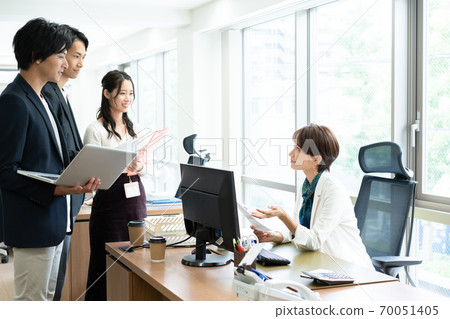 Female boss giving instructions to subordinates in the office 70051405