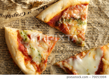 Pizza cut into English newspapers Pizza cut into English newspapers 70053994
