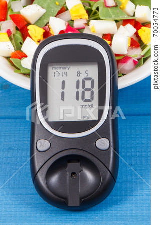 Glucometer with result of sugar level and fresh salad with eggs and vegetables 70054773