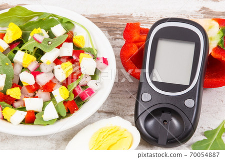 Glucometer for measurement sugar level and fresh salad with eggs and vegetables Glucometer for measurement sugar level and fresh salad with eggs and vegetables 70054887