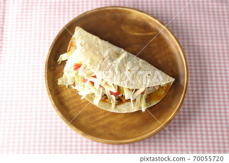 Tacos with cheese, cherry tomatoes, minced meat, etc. placed on a round wooden plate (overhead view) Tacos with cheese, cherry tomatoes, minced meat, etc. placed on a round wooden plate (overhead view) 70055720