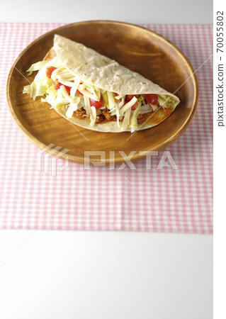 將炸玉米餅和奶酪，櫻桃番茄，碎肉等放在圓形木製板上 70055802