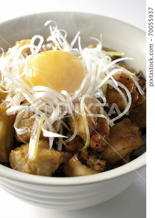 Hot bowl with white onion and egg yolk on top of yakitori grilled over charcoal (white background) 70055937