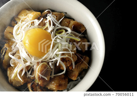 A hot bowl of white-haired green onions and egg yolks on top of a charcoal-grilled yakitori (black background, bird's-eye view) A hot bowl of white-haired green onions and egg yolks on top of a charcoal-grilled yakitori (black background, bird's-eye view) 70056011