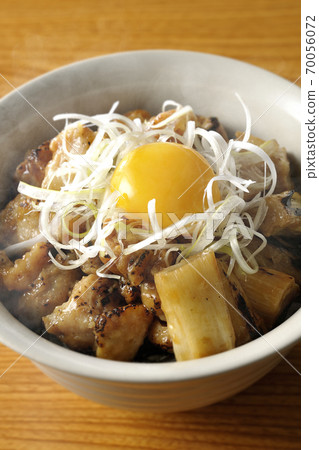 A hot bowl of white-haired green onions and egg yolks on top of a charcoal-grilled yakitori A hot bowl of white-haired green onions and egg yolks on top of a charcoal-grilled yakitori 70056072