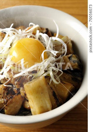 A hot bowl of white-haired green onions and egg yolks on top of a charcoal-grilled yakitori A hot bowl of white-haired green onions and egg yolks on top of a charcoal-grilled yakitori 70056073