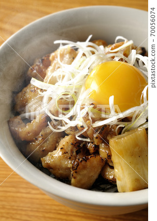 A hot bowl of white-haired green onions and egg yolks on top of a charcoal-grilled yakitori A hot bowl of white-haired green onions and egg yolks on top of a charcoal-grilled yakitori 70056074