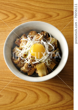 A hot bowl of white-haired green onions and egg yolks on top of a charcoal-grilled yakitori (overhead view) 70056111