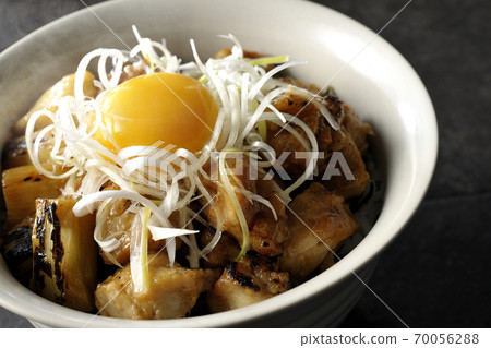 A hot bowl of white-haired green onions and egg yolks on top of a charcoal-grilled yakitori 70056288