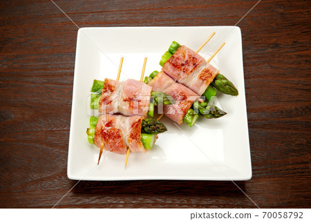 Skewed asparagus wrapped in bacon Skewed asparagus wrapped in bacon 70058792