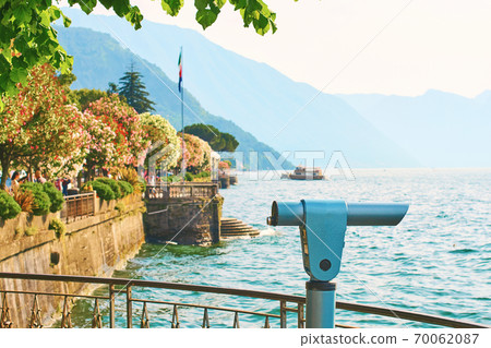 Beautiful sunny summer view of Bellagio town at lake Como in Italy with blooming nerium oleander flowers, ships and boats Beautiful sunny summer view of Bellagio town at lake Como in Italy with blooming nerium oleander flowers, ships and boats 70062087