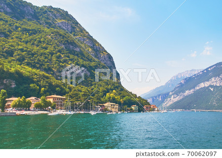 Steep alpine banks of beautiful lake Como with parked boats and yachts near village of Pare, Italy 70062097