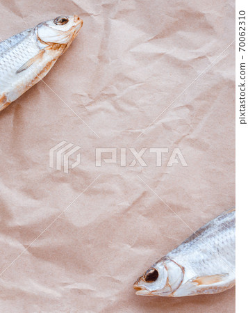 Dried fishes flat lay template banner on craft paper background with empty space for text. Vertical salted roach cover backdrop. Seafood snack poster, flyer design. Fish frame promotion shop Dried fishes flat lay template banner on craft paper background with empty space for text. Vertical salted roach cover backdrop. Seafood snack poster, flyer design. Fish frame promotion shop 70062310